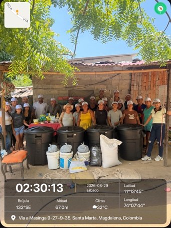 Grupo de participantes junto a los tanques instalados para la biofábrica comunitaria de bioinsumos