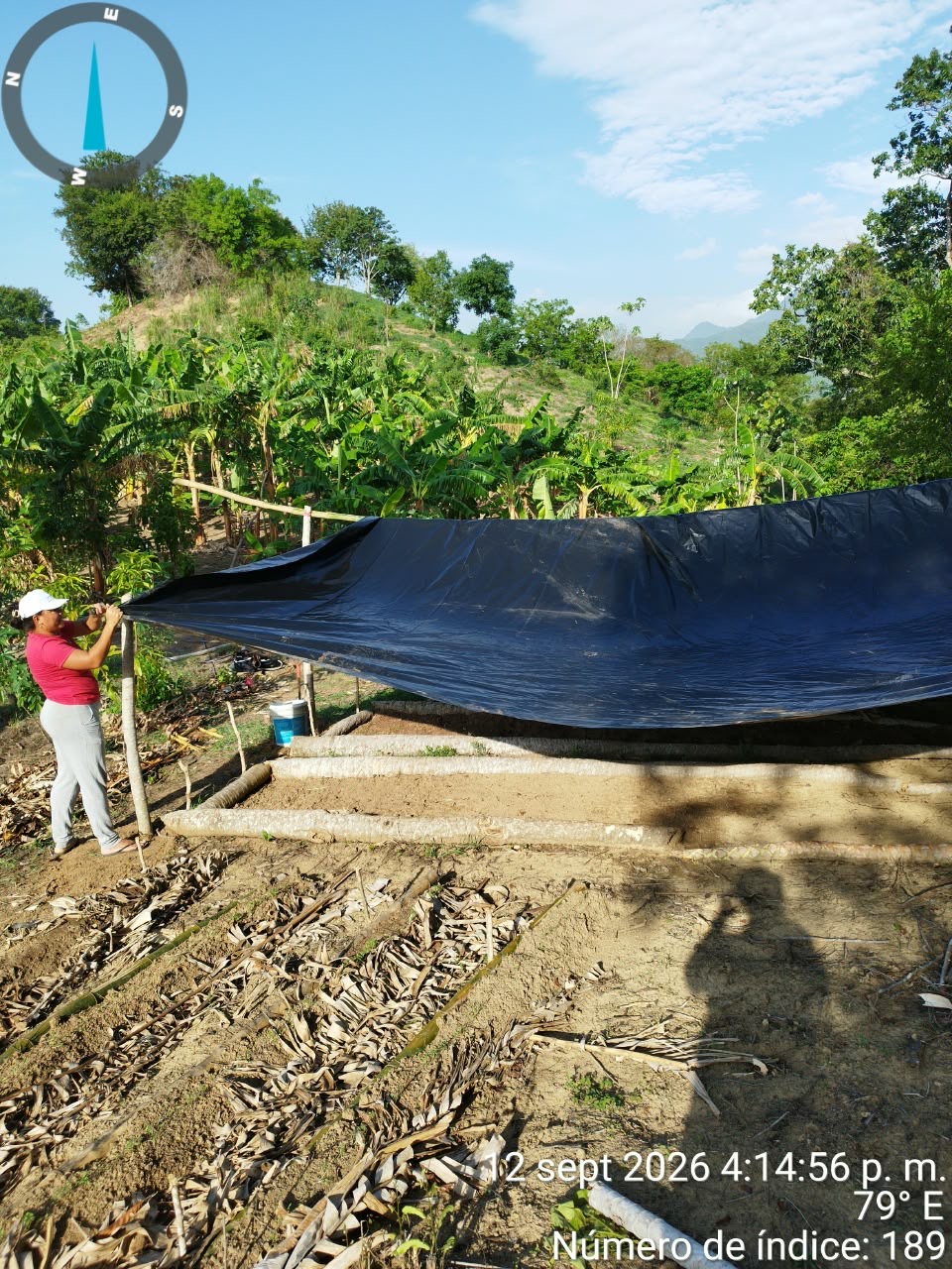Participante instalando la cubierta plástica sobre las camas de compostaje de la biofábrica comunitaria