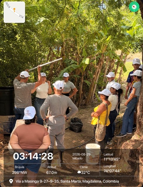 Grupo de participantes en un recorrido técnico bajo un cultivo de plátano